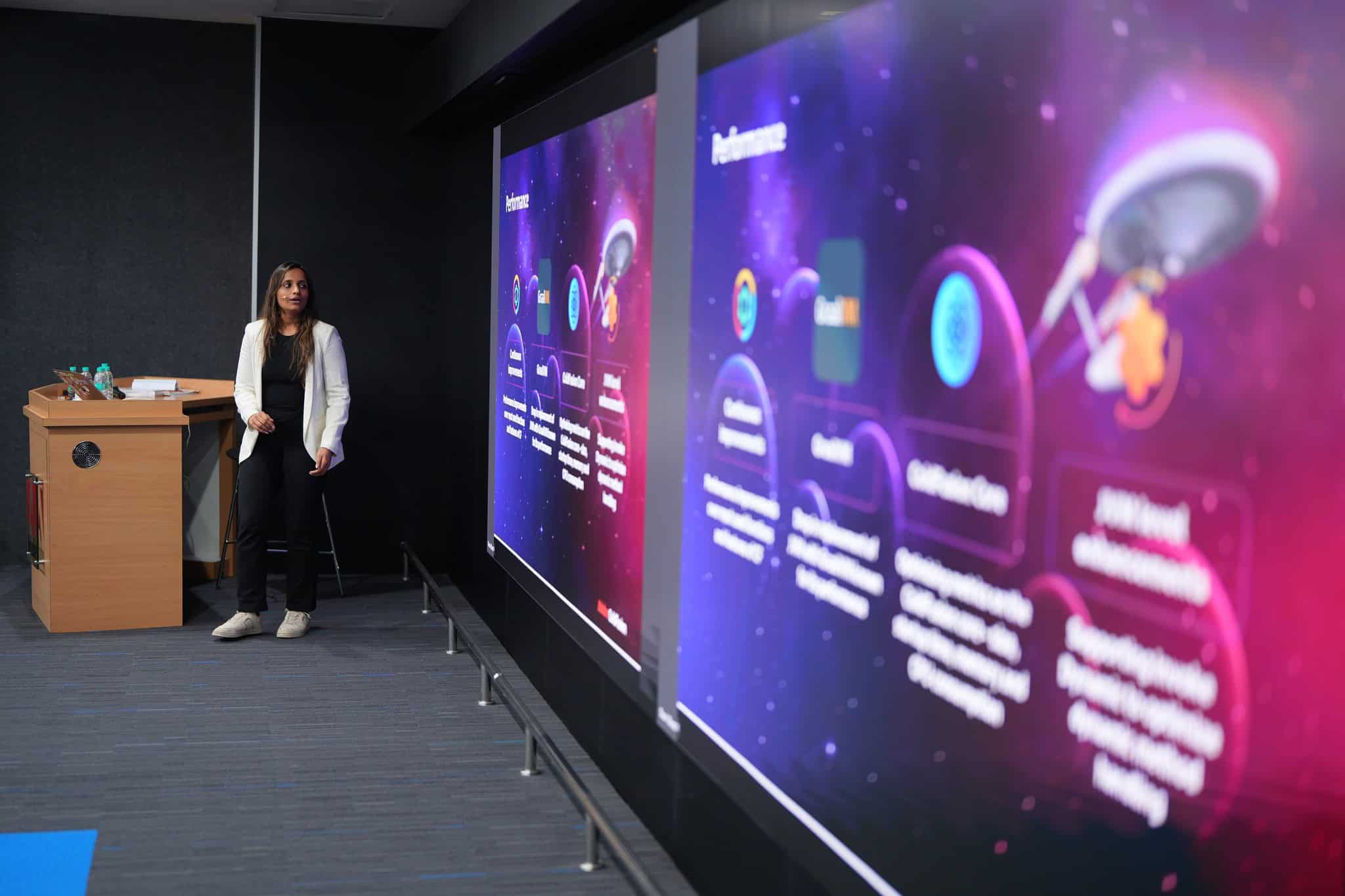 Presenter At Adobe Coldfusion Summit India With Large Digital Screens Displaying Presentation Slides.