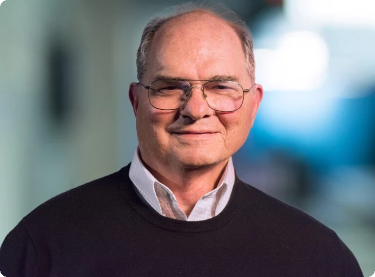 Image Of A Senior Executive With Glasses, Dressed In Business Casual, Representing Teratech’s Tech Leadership And Corporate Professionalism.